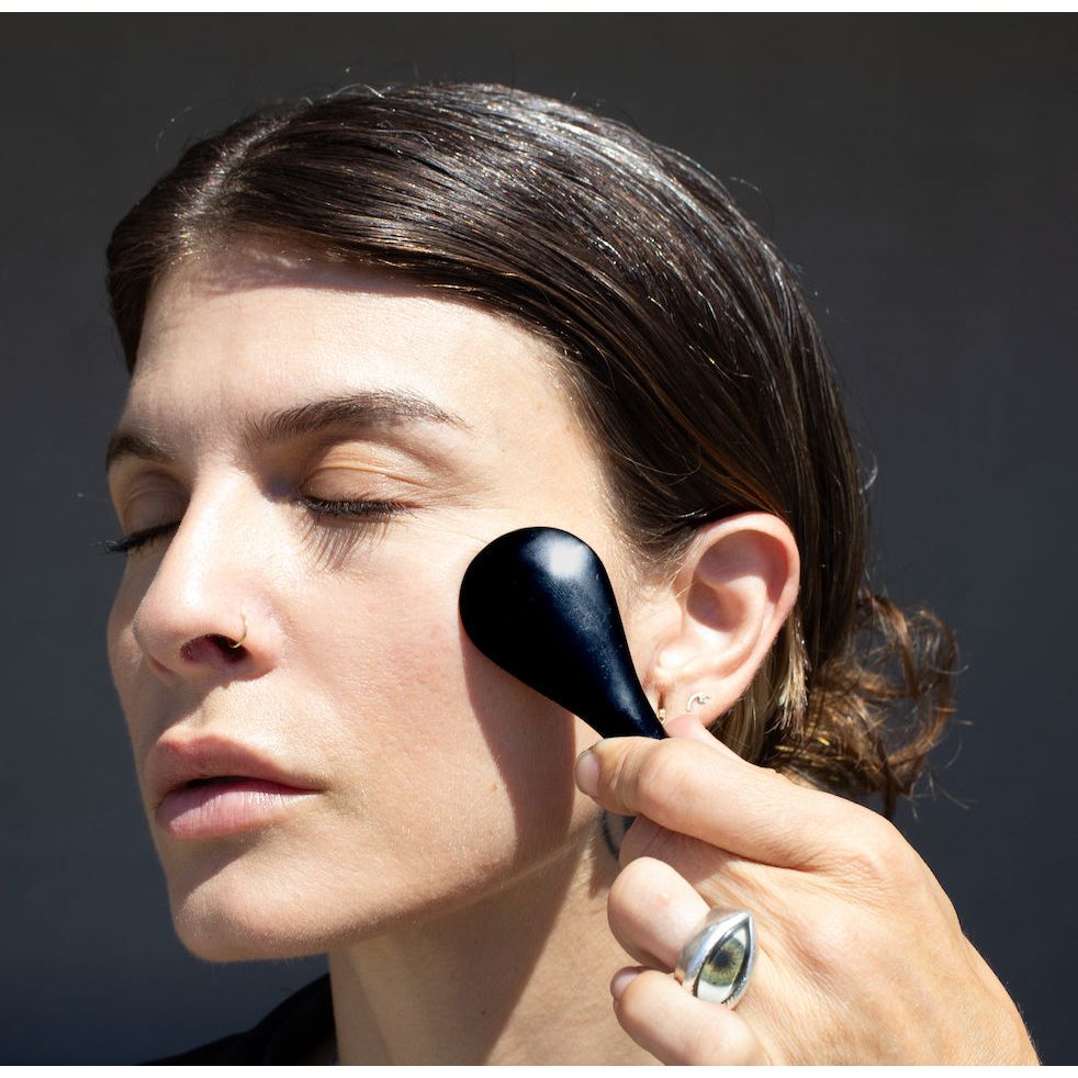 model massaging face with noto botanics face tool 