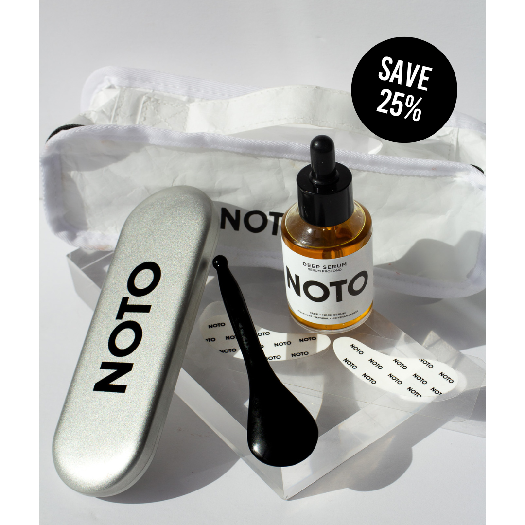 A product image featuring THE FACE SCULPT KIT by NOTO, including a bottle of deep serum, a bian stone face tool, eye boost masks, and a TYVEK recycled carry-all bag.